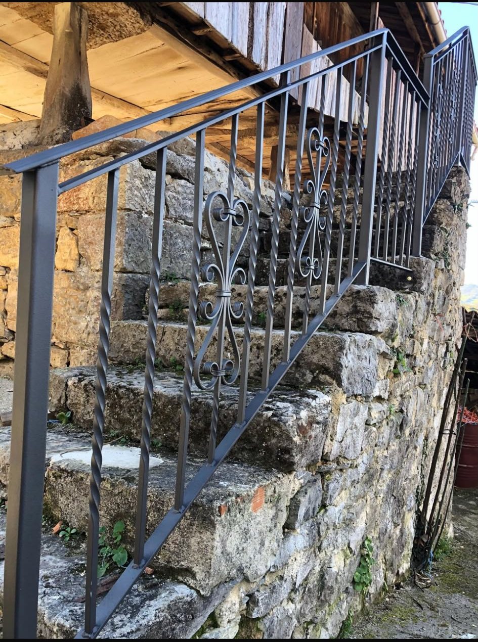 Barandilla forjada restaurada sobre escalera de piedra