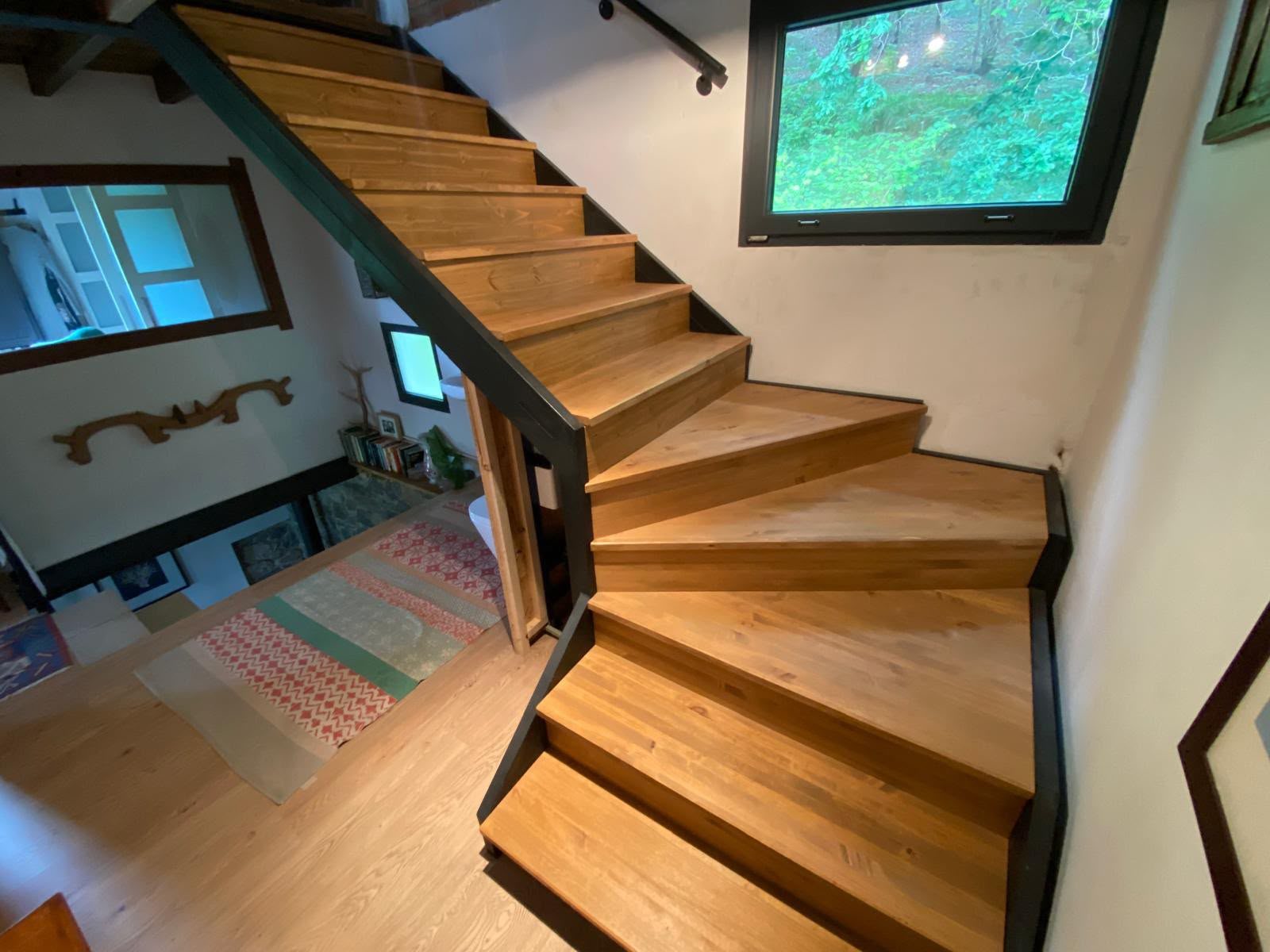 Escalera interior combinando madera y estructura de hierro
